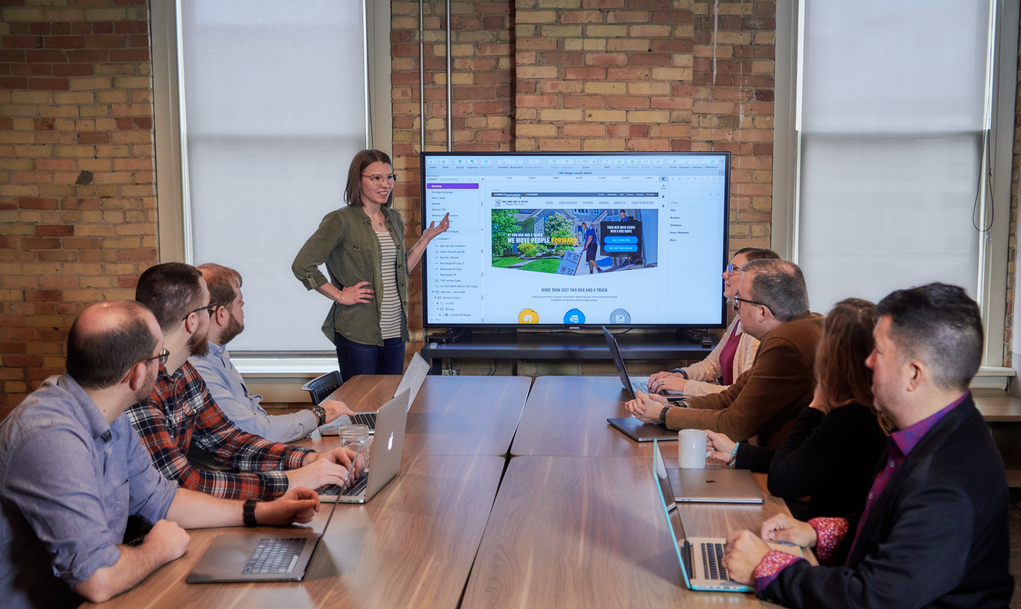 RDG team member presents screen to meeting table full of coworkers