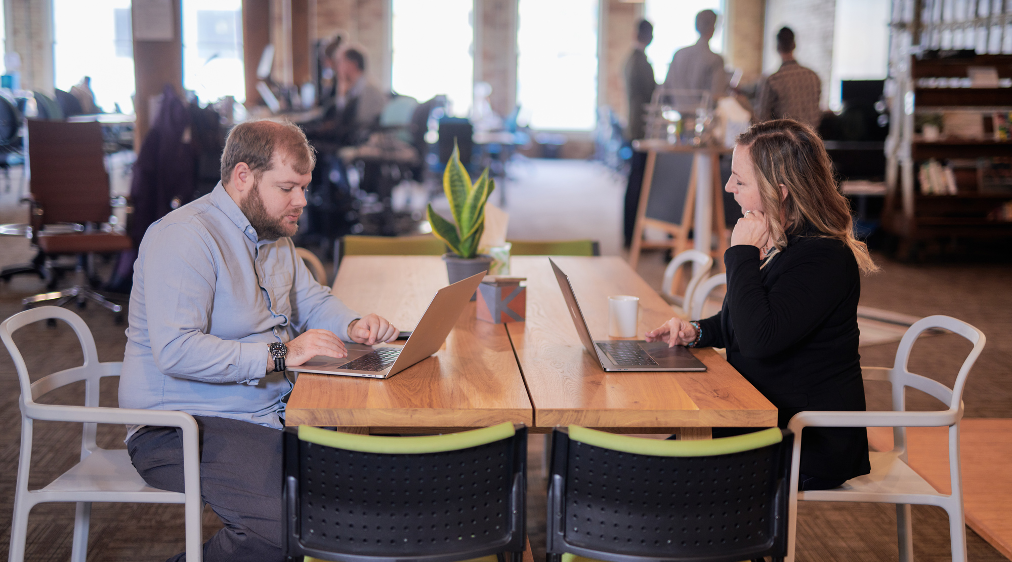 Two RDG team members working on laptops at a table