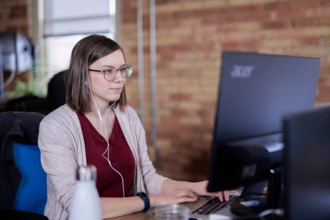 RDG team member tests website accessibility with a screen reader and headphones