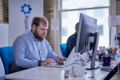 RDG team member writes code on laptop at their desk