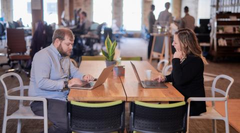 Two RDG team members working on laptops at a table