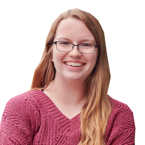 Riley head and shoulders, with glasses, light brown hair, and a dusty pink sweater