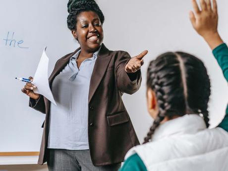 Teacher pointing to a student whose hand is raised.