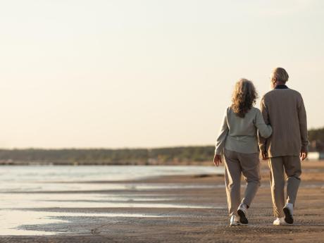 Senior couple walking along shoreline