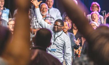 A group of people raising their hands in worship